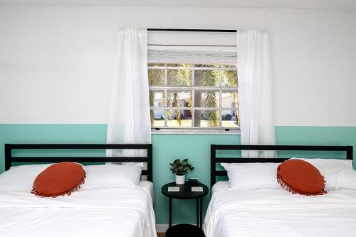 two beds in a room with a window at Sunny Escape: Vibrant Pool Home in Port Richey