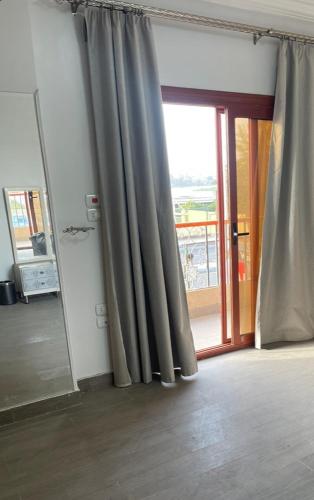Habitación con cortina y puerta con ventana en Apartment in Luxor Resort, next to Raya Market en Nag` Naqsha