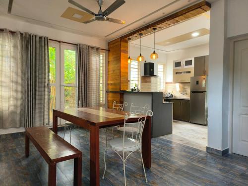 a kitchen and dining room with a wooden table and chairs at Ant Homes by Afrind Hospitality in Cochin