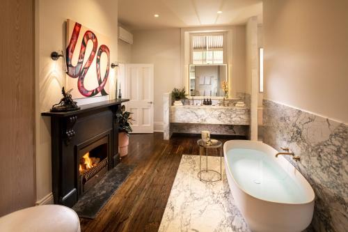 a bathroom with a bath tub and a fireplace at Kingsford The Barossa in Concordia