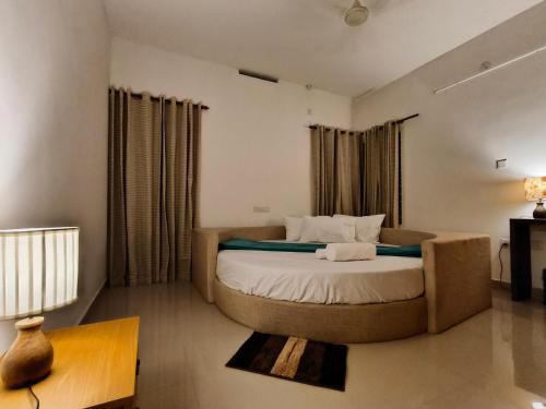 a bedroom with a large bed and a couch at Ant Homes by Afrind Hospitality in Cochin