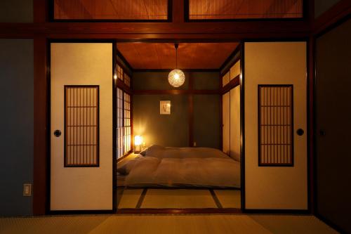 a bedroom with a bed and open doors at 貸切民泊宿 だんねだんね Private guest house Danne-Danne in Ōno