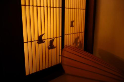 a bird cage with birds on the wall at 貸切民泊宿 だんねだんね Private guest house Danne-Danne in Ōno