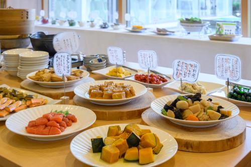 a table with plates of different types of food at Hotel Symphony Annex Sagae Onsen in Sagae