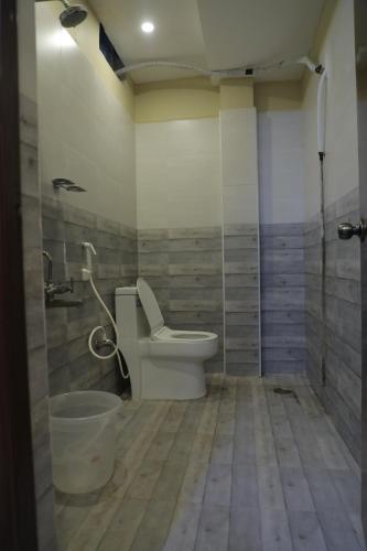 a bathroom with a toilet and a bucket in it at Nakshatra grand in Tirupati