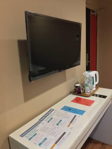 a table with a flat screen tv on a wall at M BOUTIQUE INN (BINTANG JAYA) in Miri