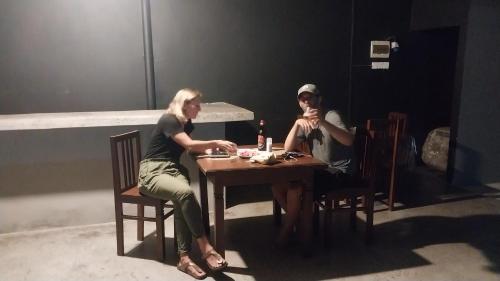 two women sitting at a table with a bottle of wine at Hotel white house mahiyanganaya in Mahiyangana