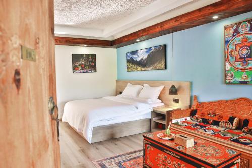 1 dormitorio con cama y escritorio con cama sidx sidx sidx sidx en 九寨沟阿布氇孜民宿Jiuzhaigou Valley Abluzi B&B, en Jiuzhaigou