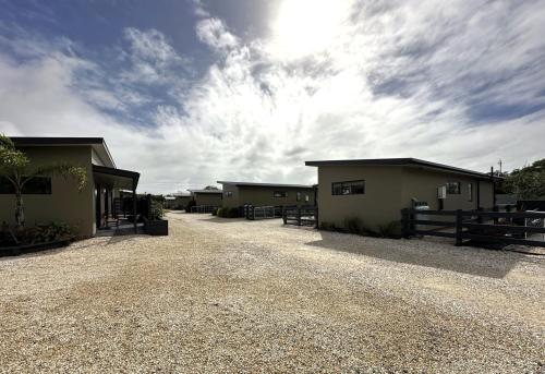 a row of buildings on a gravel road at Country Retreats on Ranzau 2 in Nelson