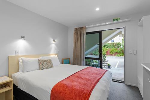 a bedroom with a bed and a large window at Bella Vista Motel & Apartments Christchurch in Christchurch