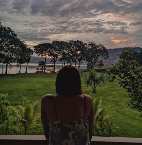 a woman looking out a window at the ocean at Maloca Inn in Sauce