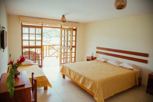 a bedroom with a large bed and a balcony at Maloca Inn in Sauce