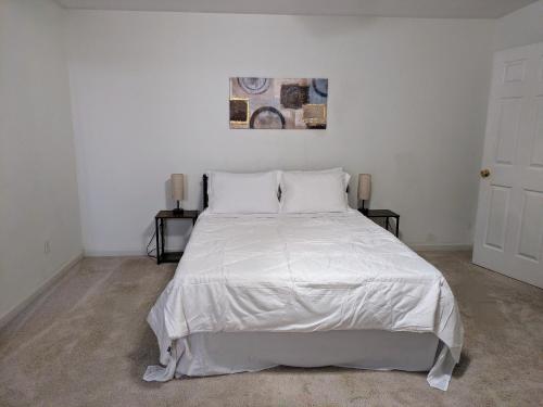 een slaapkamer met een bed met witte lakens en kussens bij Relaxing Rural Retreat In Mableton - 30 Min to ATL in Mableton