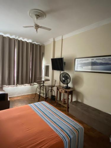 1 dormitorio con 1 cama, ventilador y TV en Melhor localização de Copa com vista para o Cristo, en Río de Janeiro