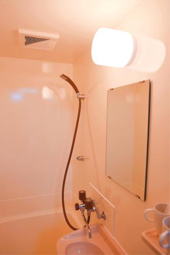 a bathroom with a shower and a sink with a mirror at 龙猫民宿-梅田店201 in Osaka