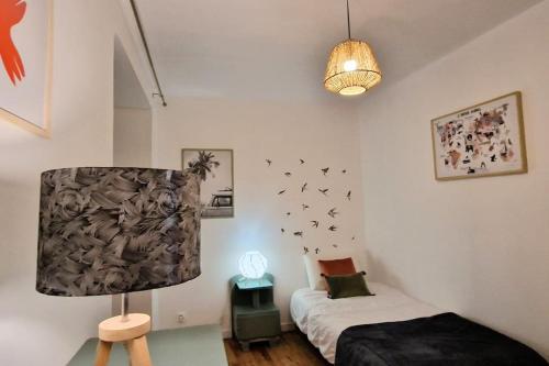 ein Schlafzimmer mit einem Bett und einer Lampe in der Unterkunft Gîte Garralda Pays Basque 6 pers in Saint-Esteben