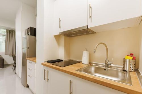 a kitchen with a sink and a refrigerator at Snug studio apartment with pvt garden access III in Athens