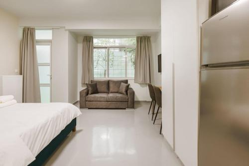 a bedroom with a bed and a chair and a window at Snug studio apartment with pvt garden access III in Athens