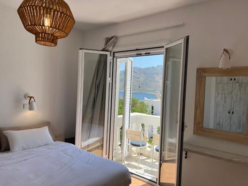 a bedroom with a bed and a balcony with a view at Nikos studios in Livadia