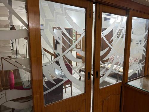 a room with two glass doors with a room with chairs at Anaha’s Homestay in Amritsar