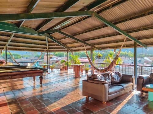 una gran sala de estar con mesa de billar y hamacas. en La Rosa Nautica Hostel, en Guaduas