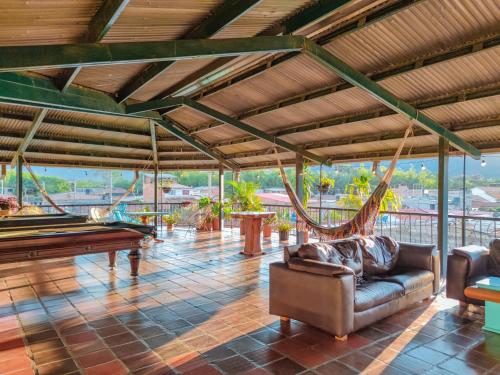 a large living room with a pool table and hammocks at La Rosa Nautica Hostel in Guaduas
