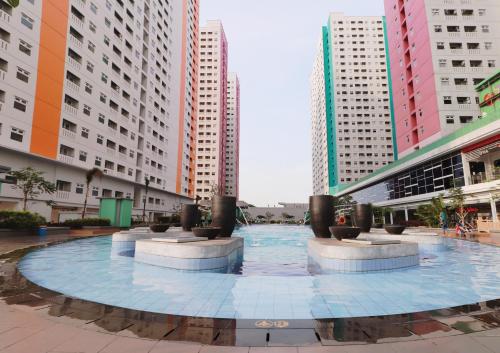 ein großer Pool in einer Stadt mit hohen Gebäuden in der Unterkunft Apartemen Green Pramuka City Tipe Studio (1 BR) in Jakarta