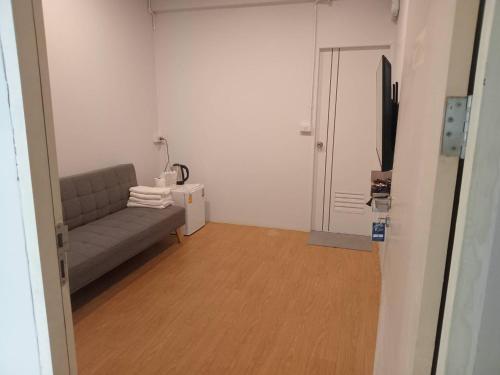 a living room with a couch and a flat screen tv at Shade House - Bitec Bangna in Bangkok