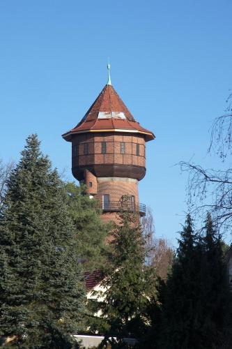 a building with a tower on top of some trees at Port Inn Hotel in Eichwalde
