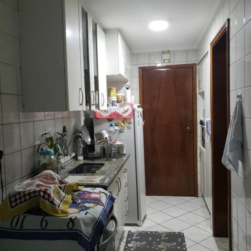 a small kitchen with a sink and a refrigerator at Meu Cantinho in Campinas