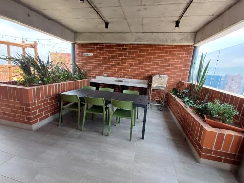 a patio with a black table and green chairs at N8 Loft estilo Industrial en Ciudad de Guatemala in Guatemala