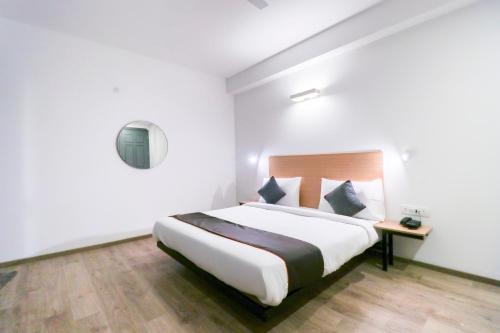 a bedroom with a large bed in a white room at OYO Townhouse 588 Noida Sector 71 Near ISKCON Temple Noida in Indirapuram