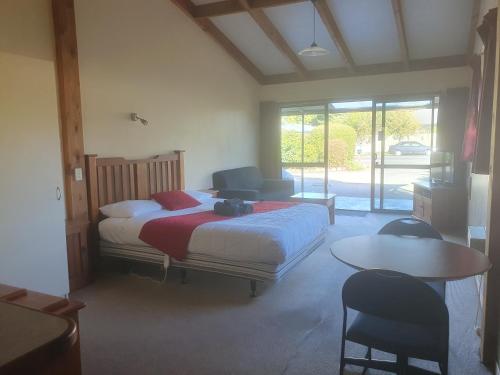 Schlafzimmer mit einem Bett, einem Tisch und Stühlen in der Unterkunft Geraldine Motels in Geraldine