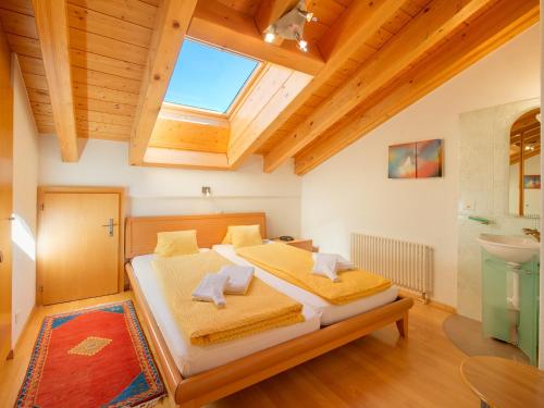 a bedroom with a bed and a bathroom with a window at Apartments Aura in Zermatt