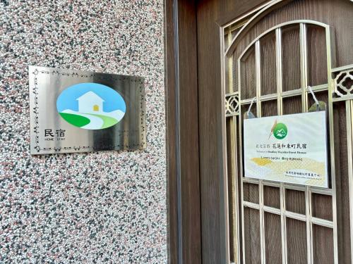 a sign on the side of a building with a window at Hualien Wazuka Homestay in Hualien City