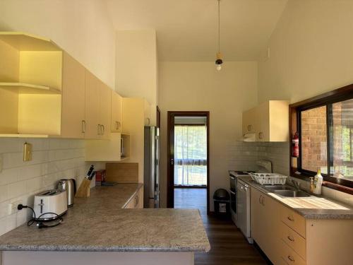 Aircabin｜KANGY ANGY｜Lovely｜4 Beds Holiday House في Tuggerah: مطبخ مع حوض و كونتر توب