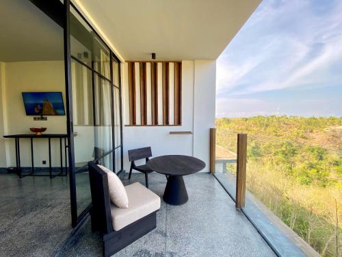 Habitación con balcón con mesa y silla. en MAUA Nusa Penida Bali en Nusa Penida