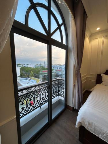 迪石的住宿－Nhật Tân Hotel，卧室设有海景阳台。