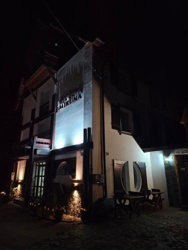 a building with a large sign on it at night at Pensiunea Miruna in Moieciu de Jos