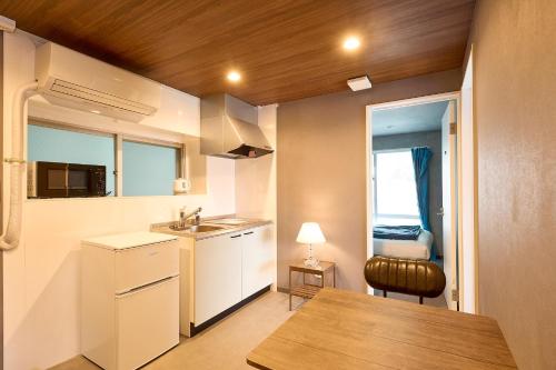 a small kitchen with a sink and a table at Hotel CABANA カバナ 宮古島 in Miyako Island
