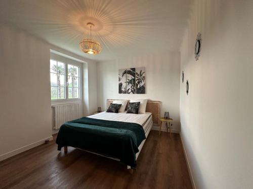 une chambre avec un lit et un lustre dans l'établissement Gîte Abarratea, Pays Basque 6/8 p., à Saint-Esteben