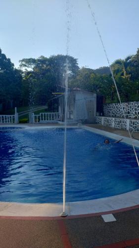 a water fountain in a swimming pool at CAMPING Y PISCINA LOS NARANJOS in Nimaima