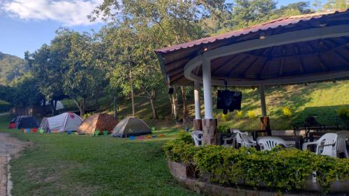Nimaima的住宿－CAMPING Y PISCINA LOS NARANJOS，草丛中的一组帐篷和椅子
