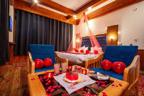 une chambre avec une table et un lit avec des ballons rouges dans l'établissement FabHotel La Kailasha Regency, à Manali