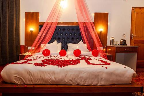 - une chambre avec un lit orné de roses rouges dans l'établissement FabHotel La Kailasha Regency, à Manali