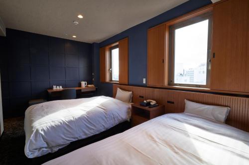 a hotel room with two beds and a window at 3s HOTEL ATSUGI in Atsugi