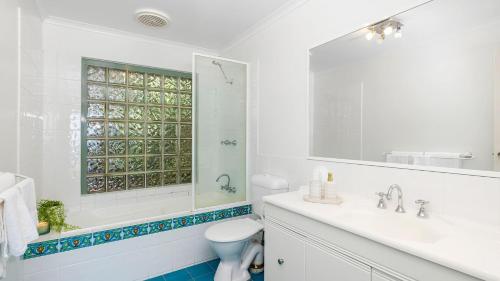 La salle de bains est pourvue d'un lavabo, de toilettes et d'un miroir. dans l'établissement On the Beach, à Fingal Bay