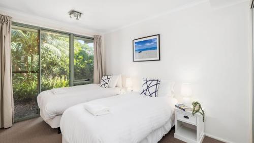 - 2 lits dans une chambre avec fenêtre dans l'établissement On the Beach, à Fingal Bay
