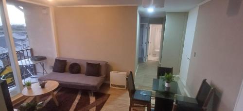 a living room with a couch and a glass table at Departamento arriendo diario in Concepción