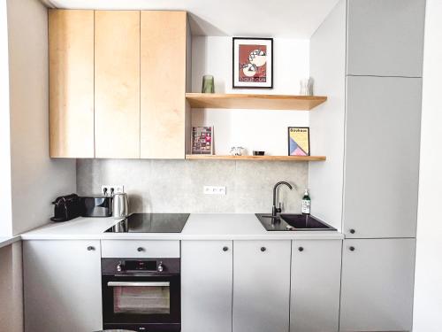 Una cocina con gabinetes blancos y un fregadero. en Apartament typu studio przy Nawrot 50, en Łódź